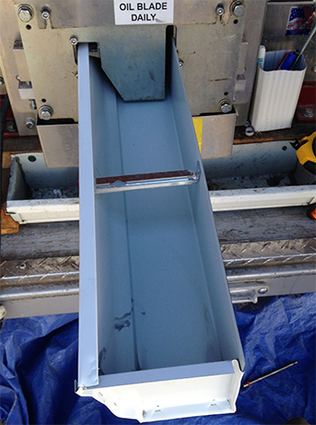 seamless aluminum gutter coming out of a gutter machine